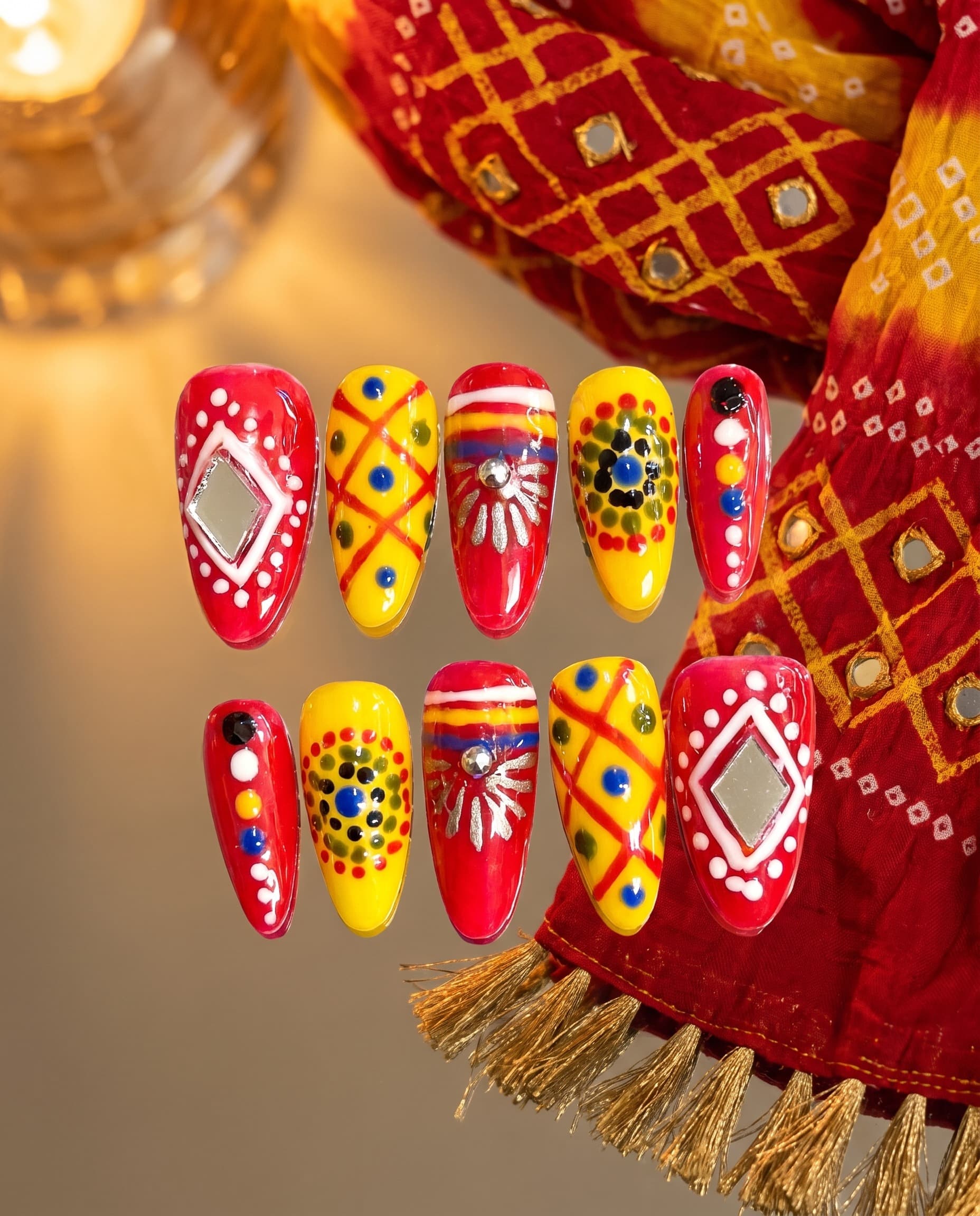 Haldi-Kumkum — Bold red and yellow bandhani crosshatch with mirror-diamond inlays and a silver sunburst, Navratri ready
