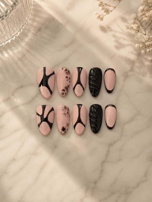 Maddy Perez — Blush-pink nails with hand-painted black tree-branch line art and one textured black nail